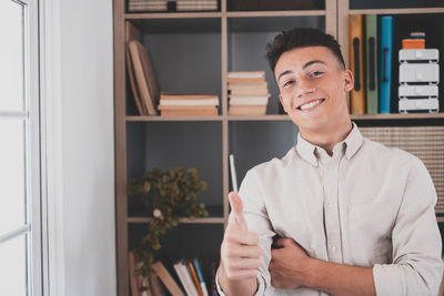 Portrait of young man standing at home