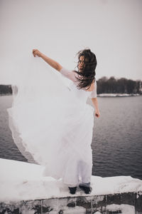 Rear view of woman standing against sea