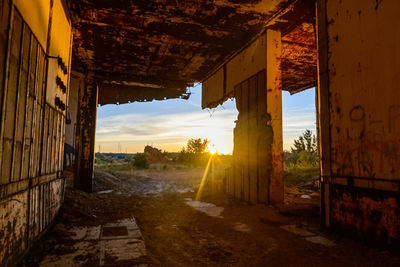 Abandoned buildings against sky during sunset