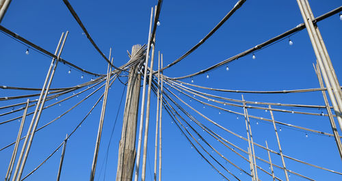 Low angle view of cables against clear blue sky