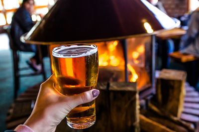 Close-up of hand holding beer glass