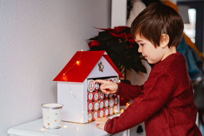 Boy holding ice cream on table at home