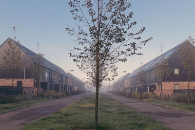 Road amidst buildings against clear sky