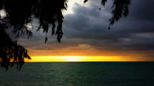 Scenic view of sea against cloudy sky at sunset