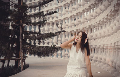 Portrait of young woman standing against sky