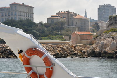 Buildings by sea against sky