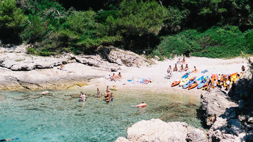 High angle view of people enjoying at beach during sunny day