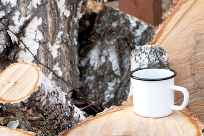 Close-up of coffee cup on tree trunk