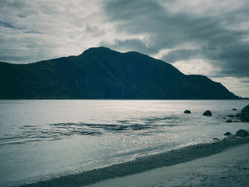 Scenic view of sea and mountains against sky