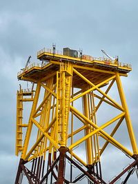 Low angle view of crane against sky