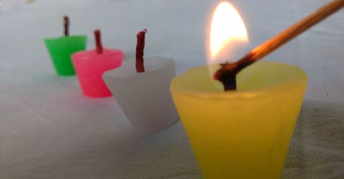 Close-up of yellow and tea light candle