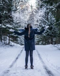 Full length of man standing on snow covered trees