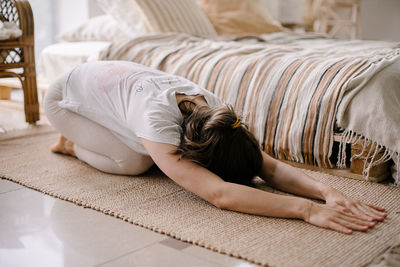 Young woman sitting on bed at home