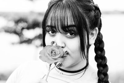 Close-up portrait of young woman with flower