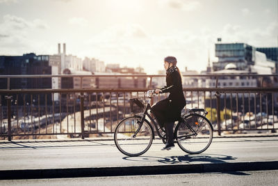 Man riding bicycle on bridge