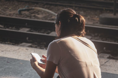 Rear view of man using mobile phone