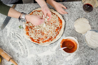 Women preparing pizza in kitchen