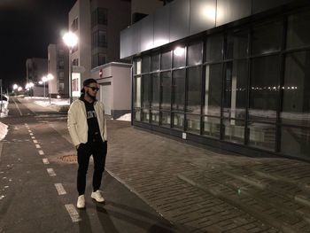 Man standing in illuminated city at night