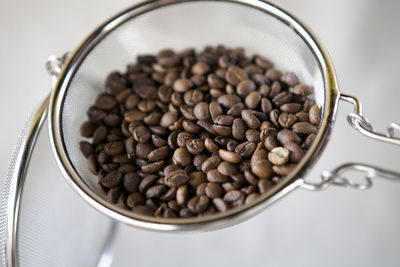 Close-up of roasted coffee beans in colander