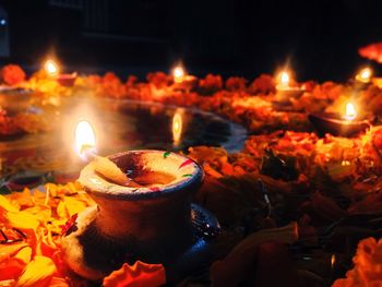 Close-up of illuminated candles on flowers at night