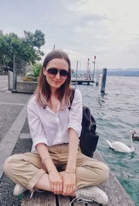 Young woman wearing sunglasses sitting outdoors