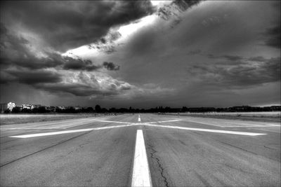 Empty road against cloudy sky