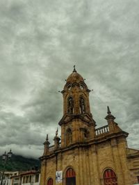 Low angle view of church against cloudy sky