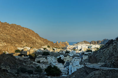 Buildings in town against clear blue sky