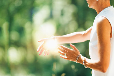 Tai chi in nature. mature woman exercising tai chi in nature, close up on hands