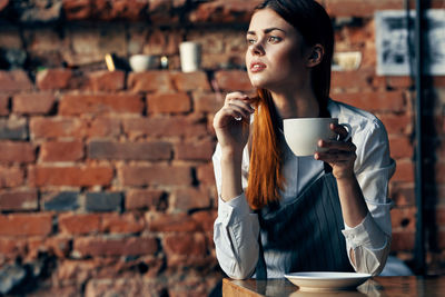 Young woman drinking coffee at cafe