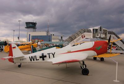 Airplane on airport runway against sky