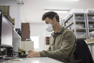 Man working on table with mask