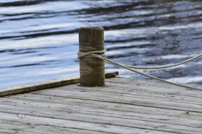 Close-up of rope tied on wooden pier 