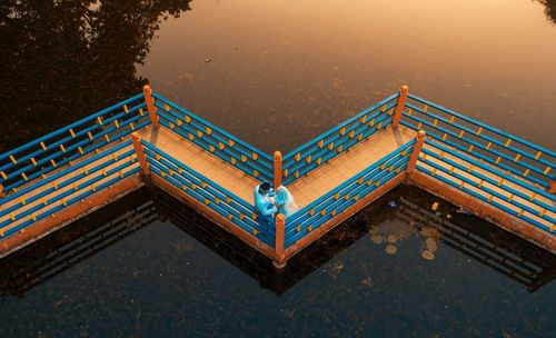 High angle view of illuminated building by lake against sky