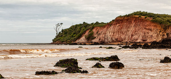 Rocks on beach against sky