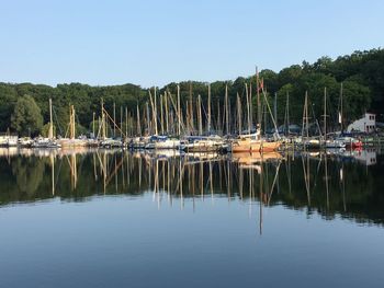 Sailboats moored in lake against sky