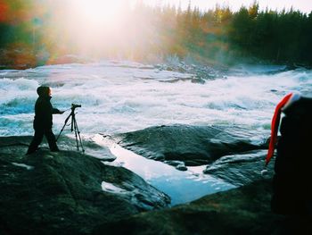 Side view of a man photographing river