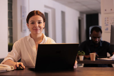 Portrait of man using laptop at office