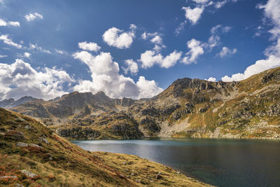 Scenic view of lake by mountains against sky