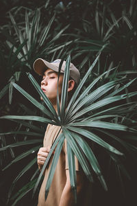 Shirtless man standing by plants