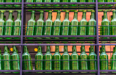 Full frame shot of green bottles on shelves for sale at store