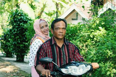 Portrait of woman with her husband riding motorcycle