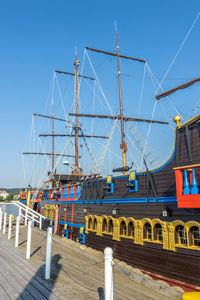 Sailboats moored in water against clear blue sky