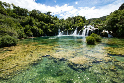 Scenic view of waterfall against sky