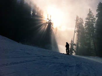 Low angle view of silhouette man skiing on snowcapped mountain