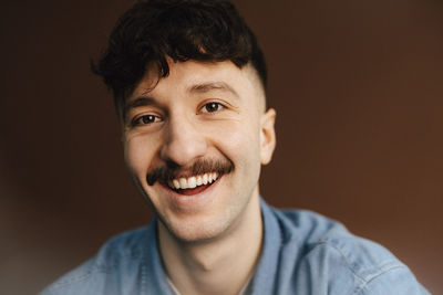 Portrait of happy man over brown background in studio
