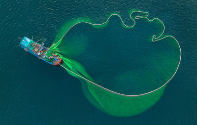 Aerial view of fishing net by boat in sea