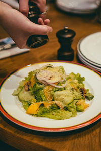 Midsection of person having breakfast in plate