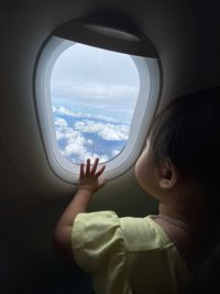 Cute girl looking through airplane window