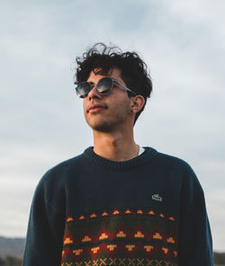 Portrait of young man standing against sky